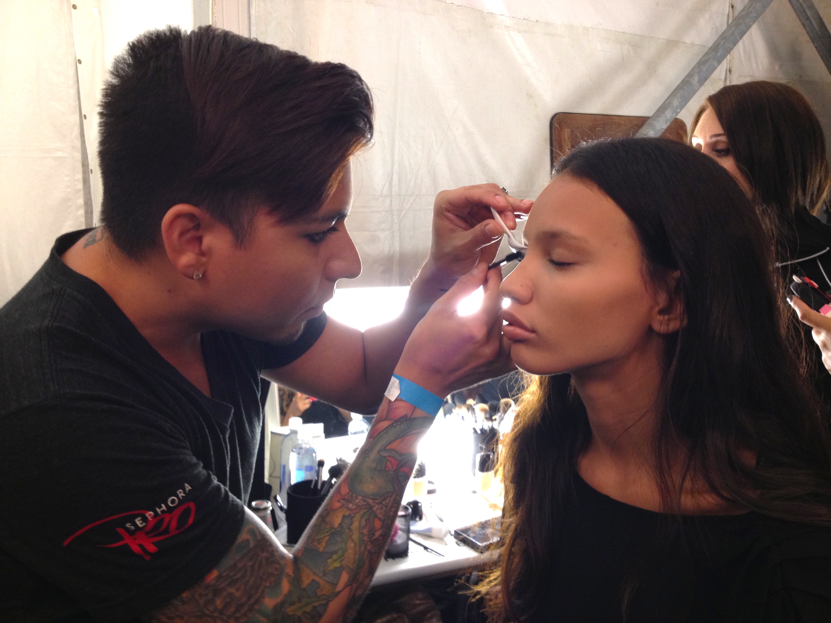 A makeup artist using Val's fan brush technique on the lashes of a model backstage at BCBGMAXAZRIA.